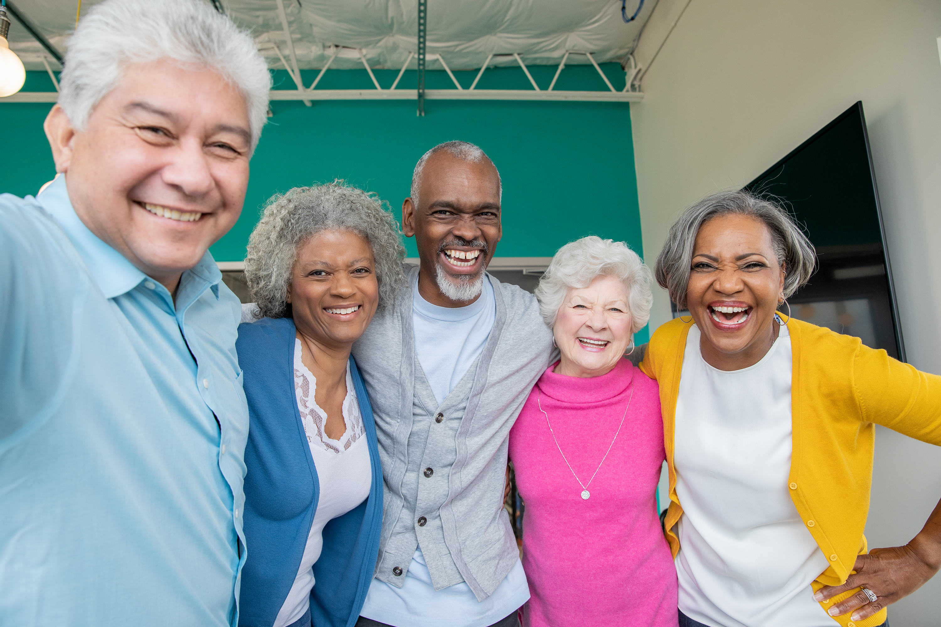 Diverse group of seniors smiling together with arms around each other